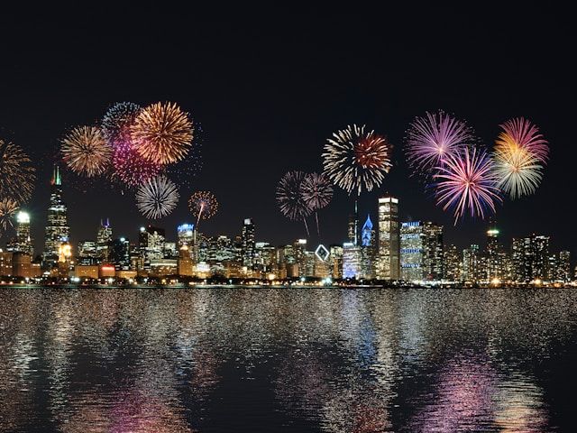 A photo of fireworks over a city skyline across the water