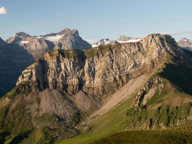 Brown and green mountains under a blue sky